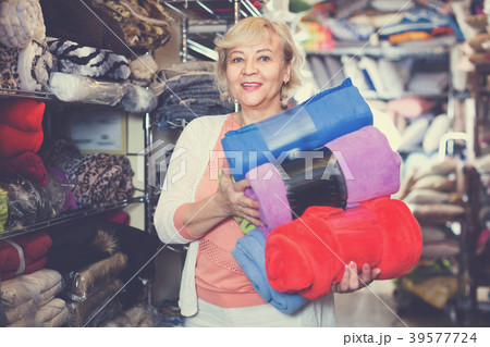 Adult female buyer choosing colour plaids in the textile store Adult female buyer choosing colour plaids in the textile store 39577724