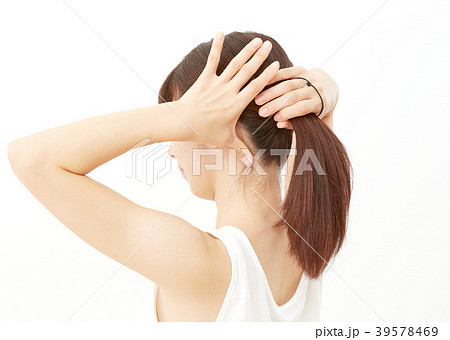 髪を結ぶ女性の写真素材