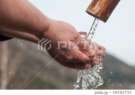 hands in the water of typical wooden fountain hands in the water of typical wooden fountain 39582735