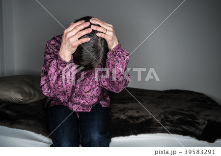 頭を抱えるシニア女性 39583291