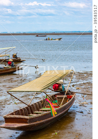 Wooden long tail boats on mud flats in Thailand Wooden long tail boats on mud flats in Thailand 39583517