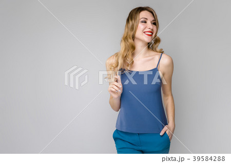 Charming young blonde girl in blue clothes smiling 39584288