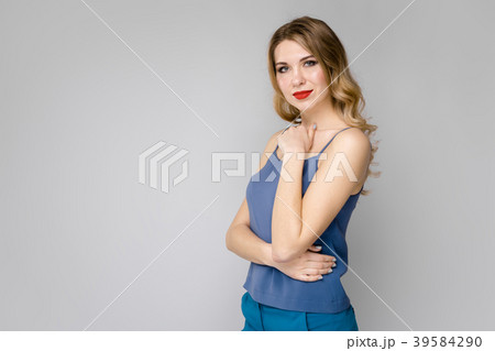 Pretty young blonde girl in blue clothes serious 39584290