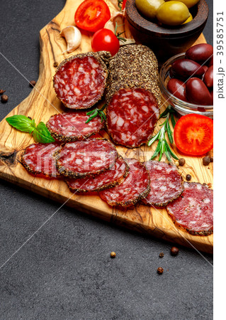 Dried organic salami sausage on wooden cutting Dried organic salami sausage on wooden cutting 39585751