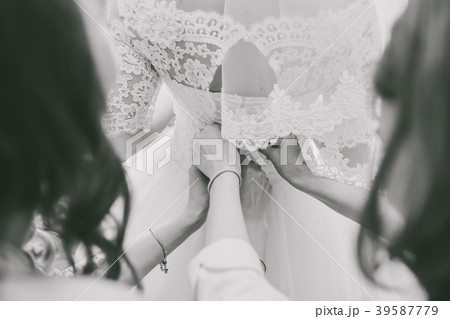 back of bride and female hands of bridesmaids 39587779