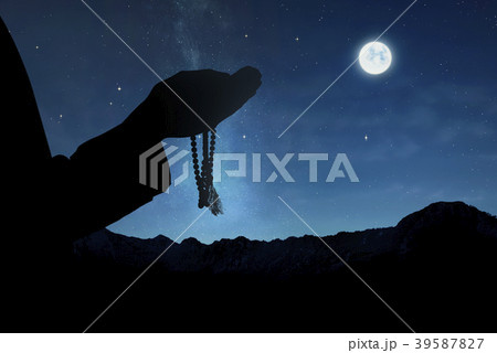 Silhouette of muslim man with prayer beads 39587827