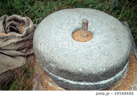 The ancient stone hand mill with grain 39588688