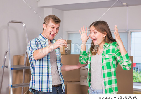 Happy young couple moving in a new house Happy young couple moving in a new house 39588696