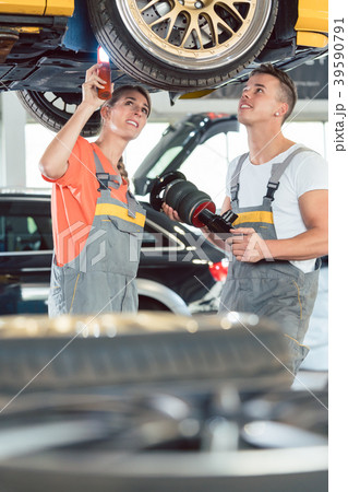 Experienced female auto mechanic with colleague at 39590791