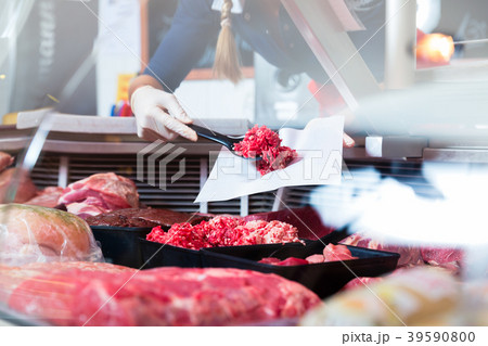 Meat in a butcher shop display being put in by 39590800