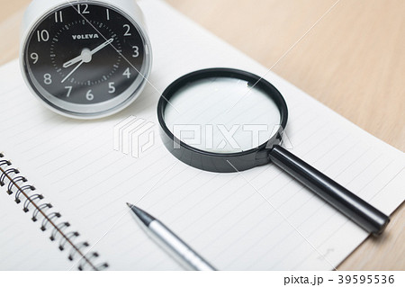 Looking through a magnifying glass to documents   39595536
