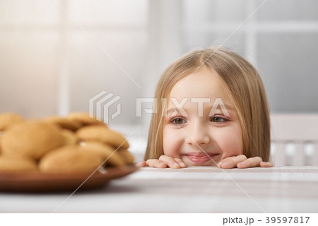 Little girl is looking on delicious cookies. Little girl is looking on delicious cookies. 39597817