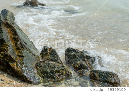 Sea rocks on the beach are surrounded by waves 39599109