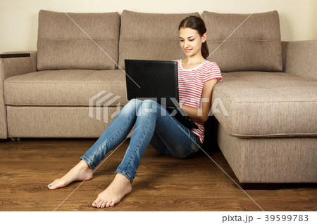 Young woman with laptop sitting on floor Young woman with laptop sitting on floor 39599783