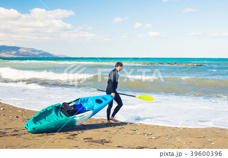 man carrying kayak at sea beach 39600396