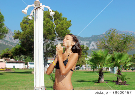 girl taking shower on the beach after sunbathing girl taking shower on the beach after sunbathing 39600467