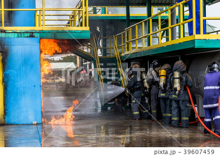 Firemen using water from hose for fire fighting. Firemen using water from hose for fire fighting. 39607459