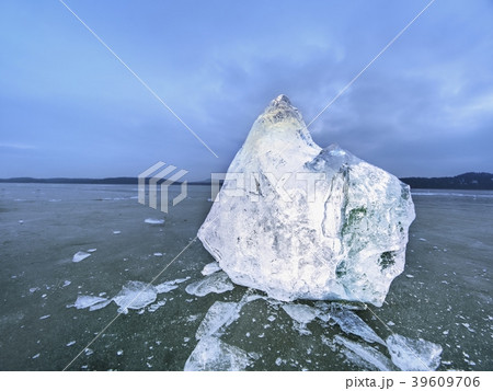 Image of pieces of ice and drops on frost ground. 39609706