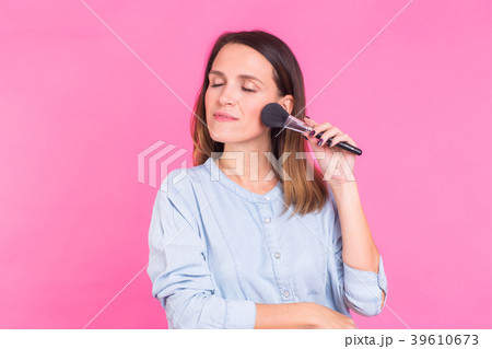 Beautiful young woman applying cosmetic powder on 39610673