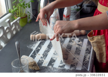 Woman rolling dough for pasta at the kitchen table 39610931