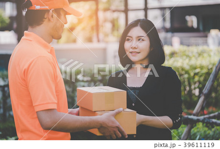 Delivery man in orange is handing packages Delivery man in orange is handing packages 39611119