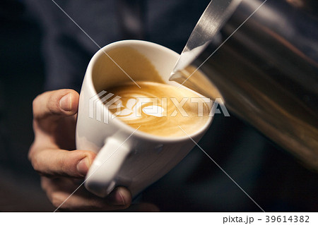 Hand of barista making latte or cappuccino closeup Hand of barista making latte or cappuccino closeup 39614382