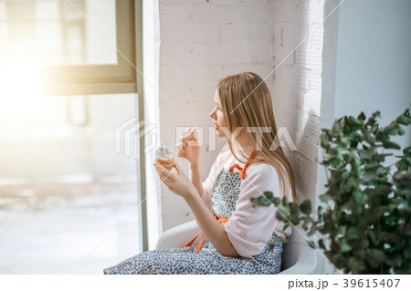 Side view of beautiful young woman tasting cupcake Side view of beautiful young woman tasting cupcake 39615407