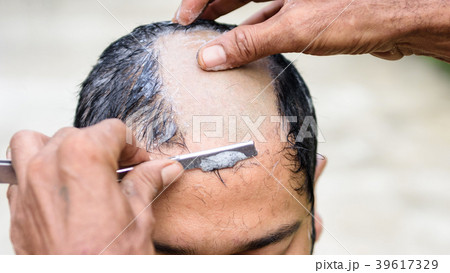 Shaved hair for ordained Buddhist man 39617329