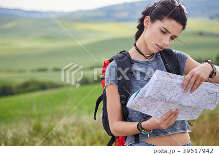 women with paper map waving at car on a concrete road in the cou 39617942