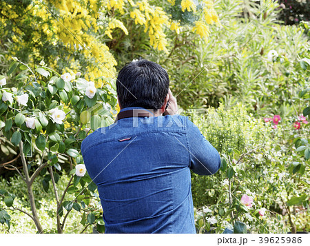 カメラを構える中年男性の後ろ姿の写真素材