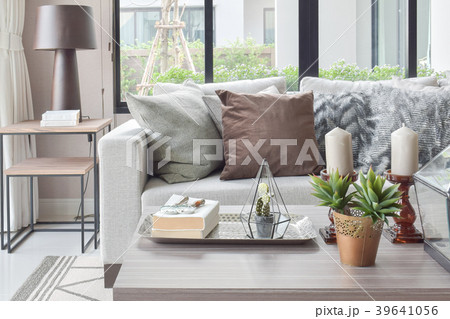 Brown pillows on beige sofa with candles on table 39641056