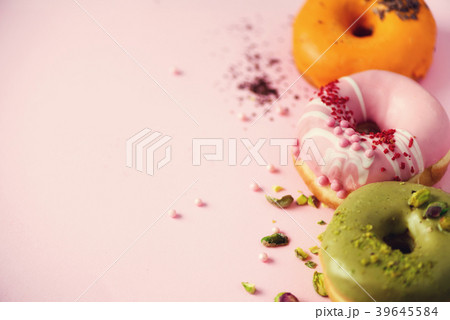 Colorful donuts with icing on pastel pink Colorful donuts with icing on pastel pink 39645584