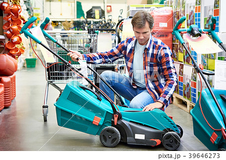Man chooses lawn mower in store Man chooses lawn mower in store 39646273