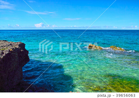 真夏の宮古島 来間島のプライベートビーチの前に広がるエメラルドグリーンの海の写真素材