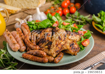 Grilled chicken wings and sausages Grilled chicken wings and sausages 39659653