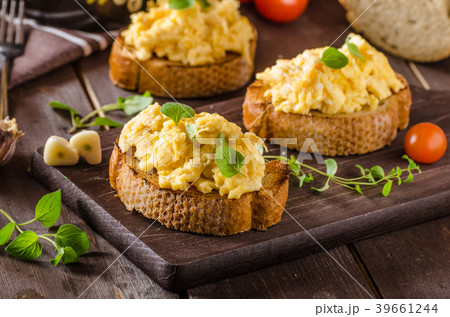 Scrambled eggs with herbs and garlic on toasted bread 39661244
