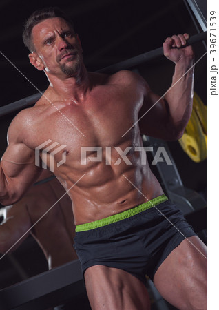 Man athlete exercising in the gym with a barbel Man athlete exercising in the gym with a barbel 39671539