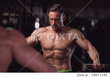 Muscular fitness model posing shirtless in the gym Muscular fitness model posing shirtless in the gym 39671586