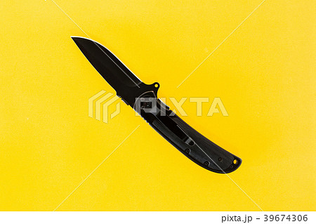 black folding knife on a yellow background. black folding knife on a yellow background. 39674306