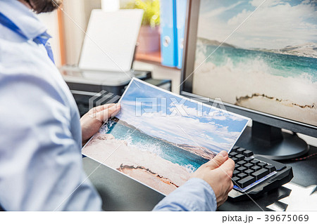 The graphic designer compares the printed photo 39675069