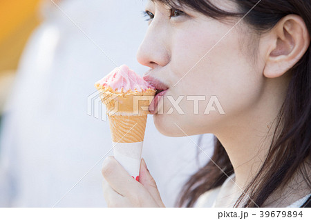 ソフトクリームを食べる女性の写真素材