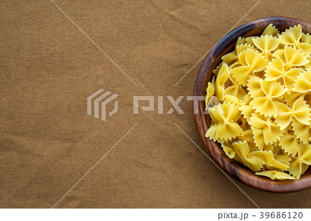 farfalle macaroni pasta in a wooden bowl on a farfalle macaroni pasta in a wooden bowl on a 39686120