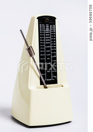Pale beige metronome in motion on white background 39686706