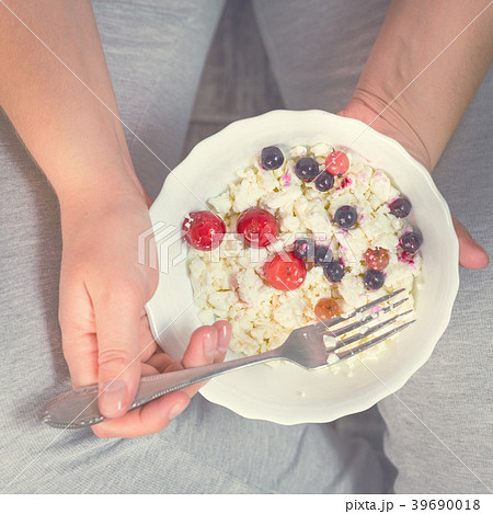 Full girl holding a plate of cottage cheese 39690018