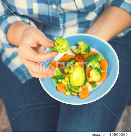 The girl holds a plate with vegetables 39690060