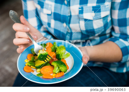 Girl with a plate of vegetables in hands 39690063