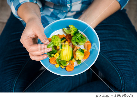 Girl with a plate of vegetables in hands 39690078