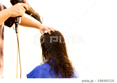 Man hairdresser using blower to dry customer hair Man hairdresser using blower to dry customer hair 39690510