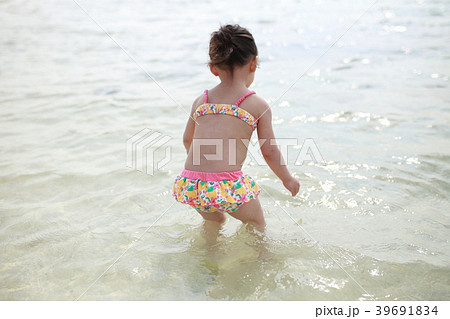 海 ビーチ 子供 女児 夏休み リゾート バカンス 家族旅行 後姿 顔なし 南国 コピースペース の写真素材