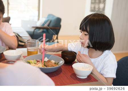 小学生の女の子と家族の食事風景の写真素材
